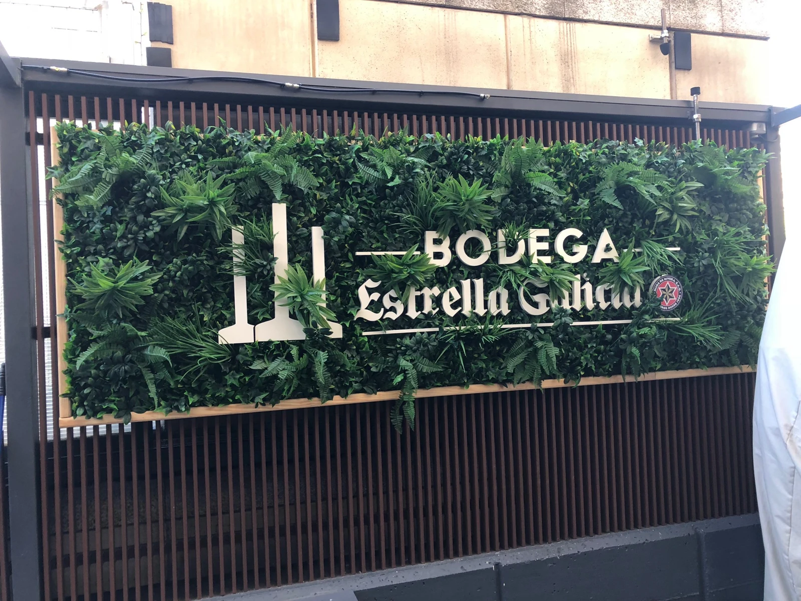 Jardín vertical con marco de madera y logo corpóreo Bodega Estrella Galicia