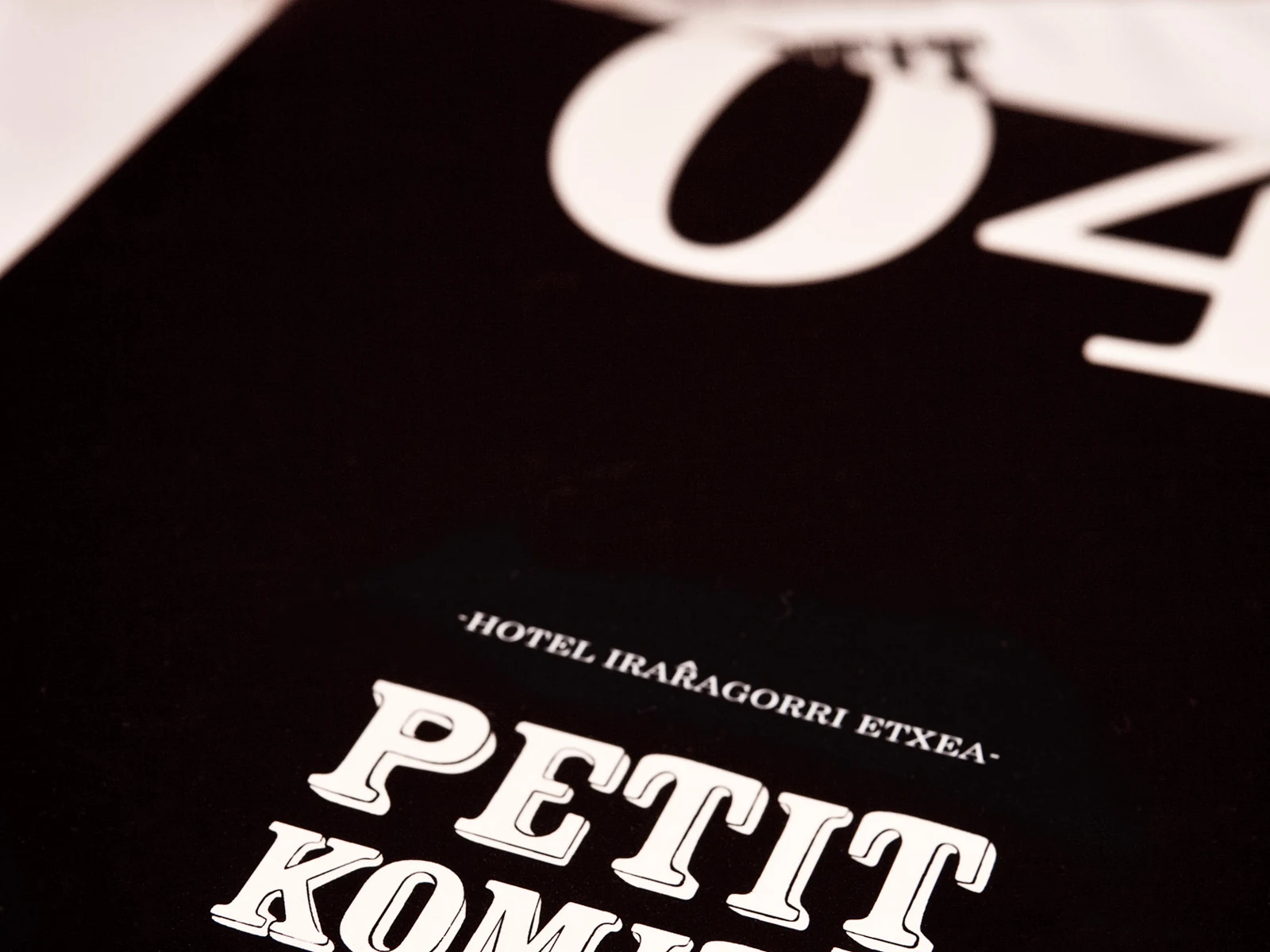 Detalle de la identidad gráfica de Petit Komité
